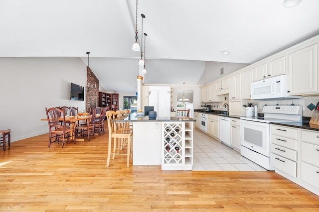 kitchen with white appliances, lofted ceiling, open shelves, light wood-style floors, and dark countertops