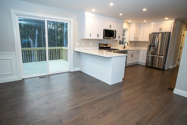 789 Royalston Rd, Phillipston, MA 01331 - kitchen with appliances with stainless steel finishes, a peninsula, white cabinets, light countertops, and dark wood finished floors