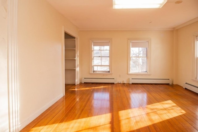 spare room featuring a baseboard radiator and hardwood / wood-style flooring