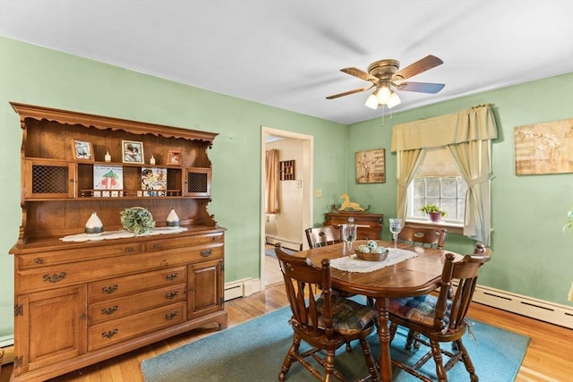 dining area with light wood finished floors, baseboard heating, and a ceiling fan