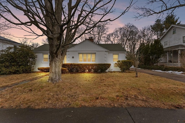 view of front of house featuring a chimney and a front lawn