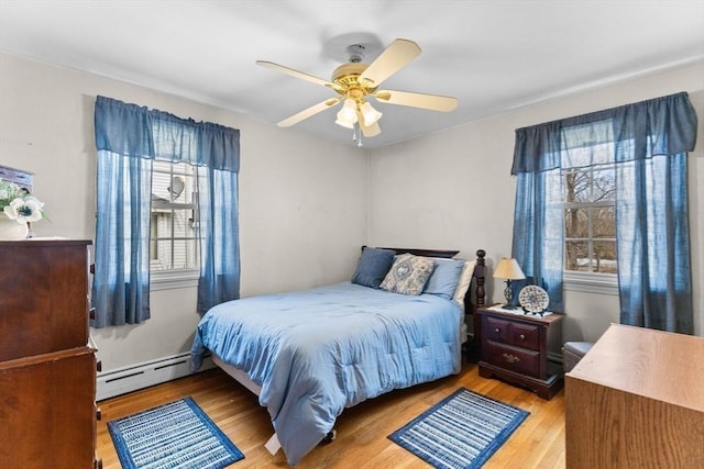 bedroom with ceiling fan, light wood finished floors, and a baseboard radiator