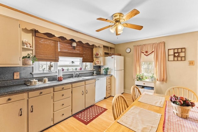 kitchen featuring white appliances, light wood finished floors, dark countertops, open shelves, and a sink