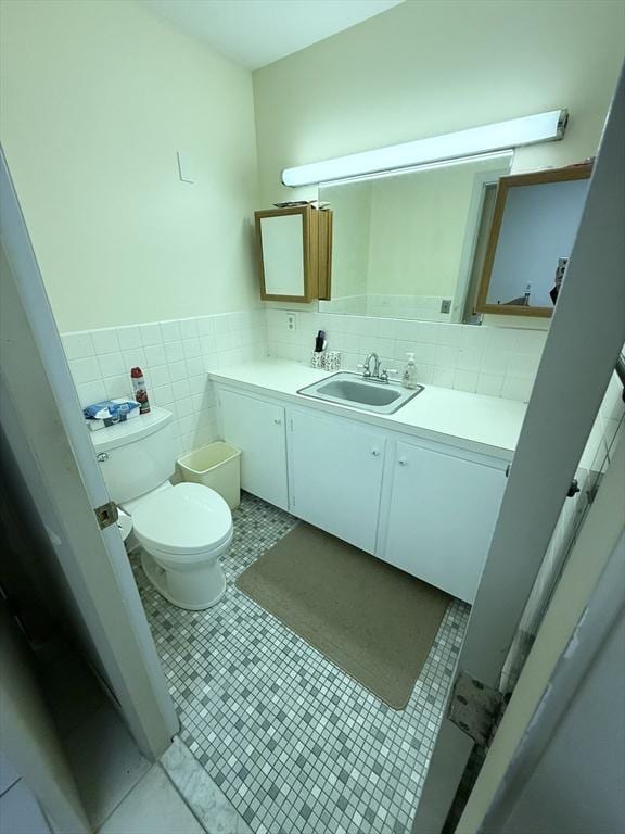 74 Fiske Hill Rd, Sturbridge, MA 01566 - bathroom with toilet, vanity, tile walls, and a wainscoted wall