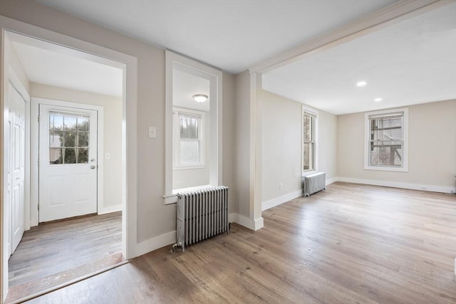 foyer entrance featuring radiator and light hardwood / wood-style flooring