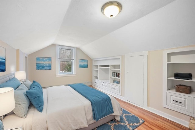 bedroom featuring vaulted ceiling and light hardwood / wood-style flooring