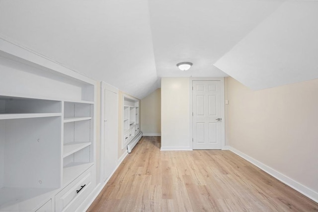 additional living space featuring lofted ceiling, built in features, light hardwood / wood-style floors, and a baseboard radiator