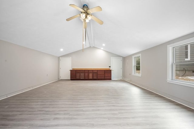 unfurnished living room with vaulted ceiling, ceiling fan, and light hardwood / wood-style flooring