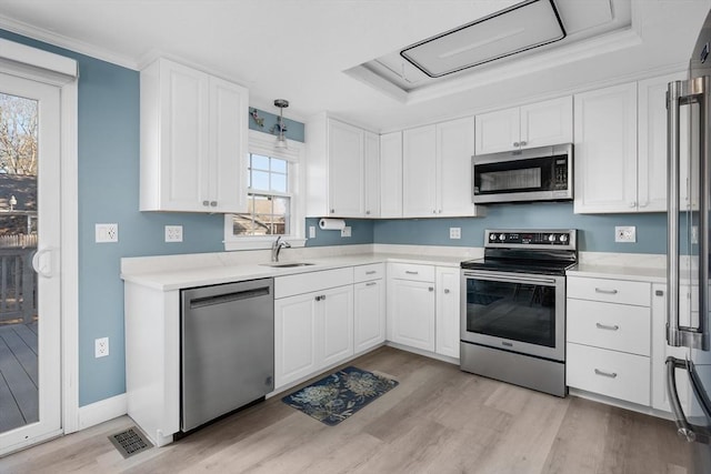 56 Baxter Ave, Yarmouth, MA 02673 - kitchen with a tray ceiling, a sink, white cabinets, and appliances with stainless steel finishes