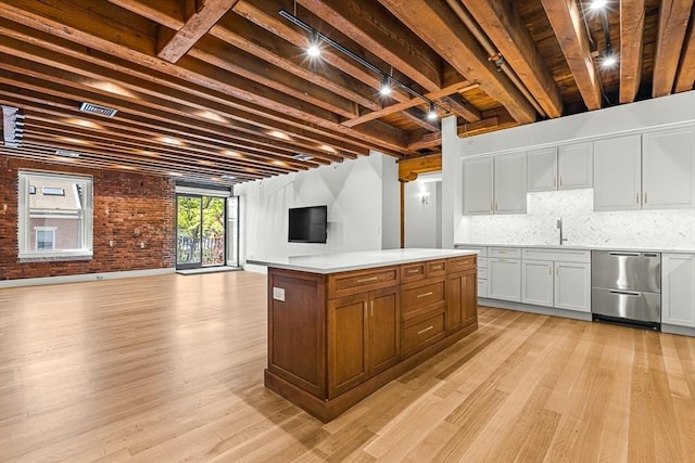 343 Commercial St Unit 212, Boston, MA 02109 - kitchen with stainless steel dishwasher, open floor plan, light wood finished floors, light countertops, and beamed ceiling