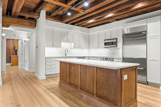343 Commercial St Unit 212, Boston, MA 02109 - kitchen with appliances with stainless steel finishes, a kitchen island, light countertops, light wood finished floors, and wood ceiling with exposed beams
