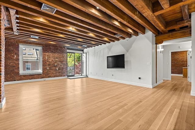 343 Commercial St Unit 212, Boston, MA 02109 - unfurnished living room featuring light wood-style flooring, beam ceiling, baseboards, and brick wall