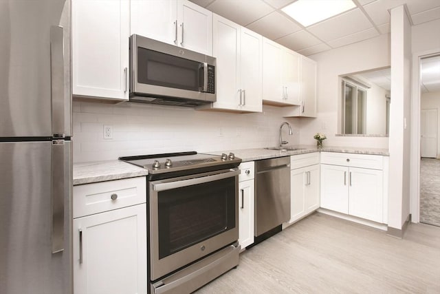 kitchen featuring a paneled ceiling, white cabinetry, and appliances with stainless steel finishes