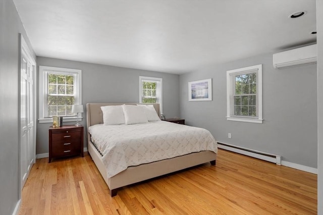 62 Bianca Rd, Duxbury, MA 02332 - bedroom with a baseboard heating unit, a wall mounted AC, multiple windows, and light wood-style floors