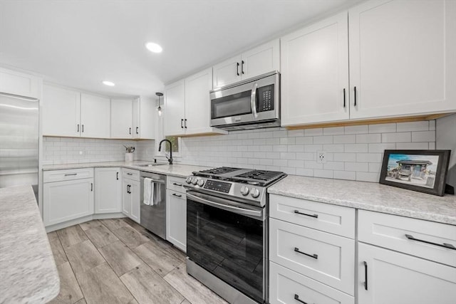 62 Bianca Rd, Duxbury, MA 02332 - kitchen featuring stainless steel appliances, a sink, white cabinetry, backsplash, and recessed lighting