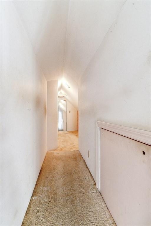 corridor with light carpet and vaulted ceiling