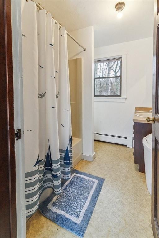 bathroom featuring baseboard heating, vanity, and shower / tub combo