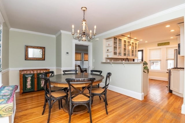 dining space with light wood-type flooring, a chandelier, and crown molding