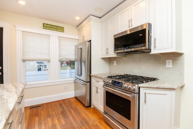 kitchen featuring light stone countertops, white cabinets, and appliances with stainless steel finishes