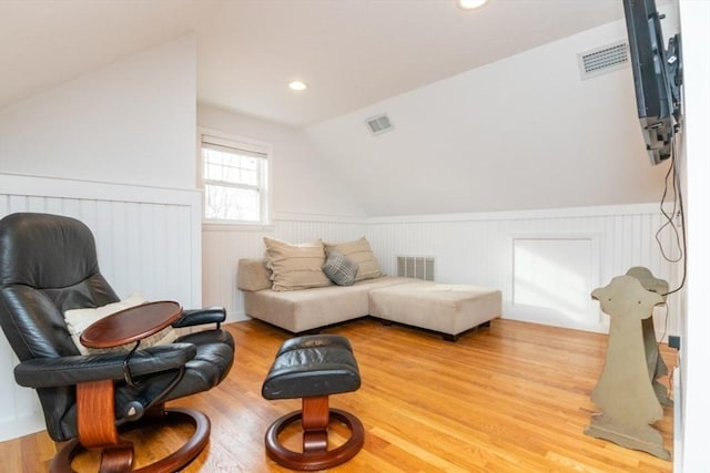 sitting room with light wood-type flooring and lofted ceiling