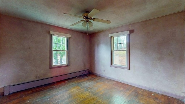 unfurnished room with ceiling fan, baseboards, hardwood / wood-style floors, and baseboard heating