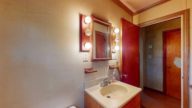 half bathroom featuring crown molding, tile patterned flooring, and vanity