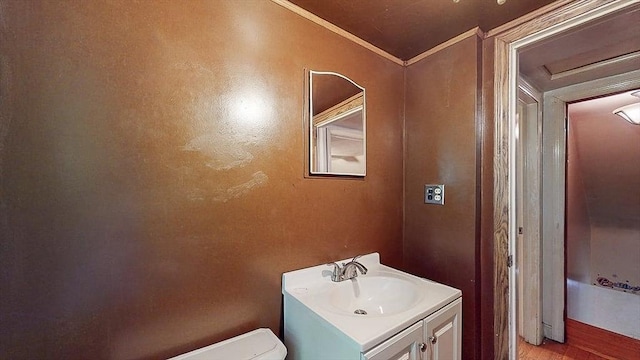 half bath featuring toilet, ornamental molding, and vanity