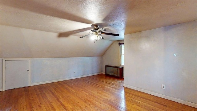 bonus room with light wood finished floors, vaulted ceiling, baseboards, and a ceiling fan