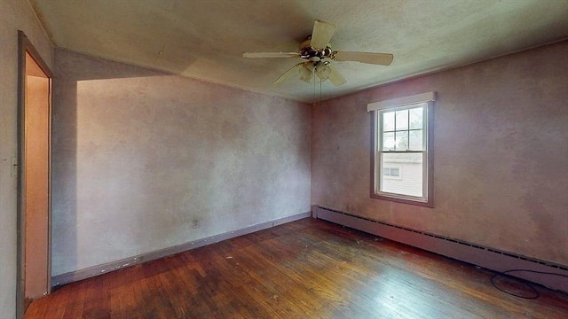 spare room featuring baseboards, a baseboard radiator, ceiling fan, and wood finished floors