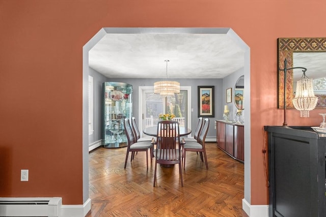 dining area featuring a chandelier, arched walkways, and a baseboard heating unit
