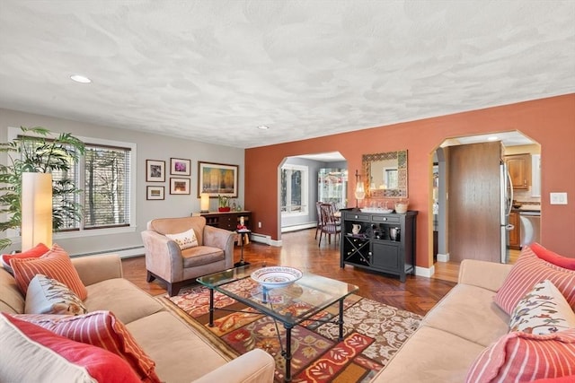 living room featuring recessed lighting, arched walkways, a baseboard radiator, and baseboards