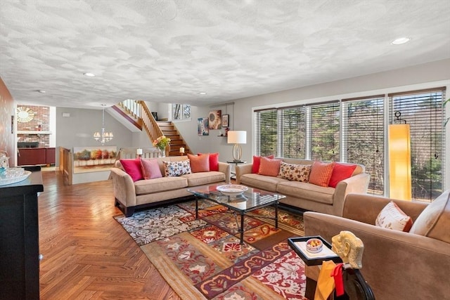 living area with a textured ceiling, recessed lighting, an inviting chandelier, and stairs