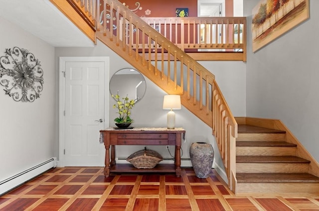 staircase with parquet flooring, baseboard heating, and baseboards