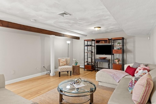 living room featuring visible vents, baseboards, baseboard heating, a textured ceiling, and wood finished floors