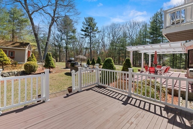 wooden deck featuring an outbuilding and a pergola
