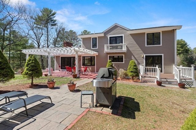 rear view of house featuring a pergola, a patio, a chimney, and a lawn