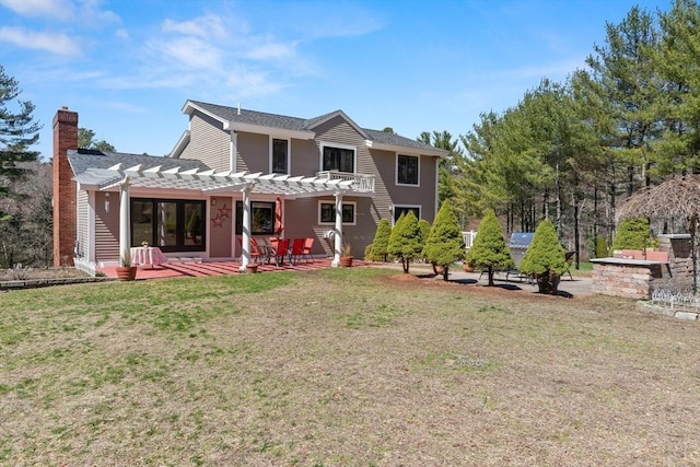 back of house with a pergola, a yard, a patio, and a chimney
