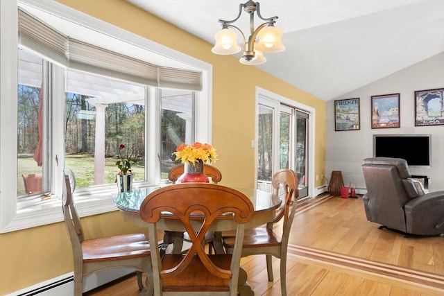 dining area with a chandelier, light wood-type flooring, a baseboard radiator, and lofted ceiling