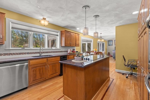 kitchen featuring dishwasher, a center island, a sink, and backsplash