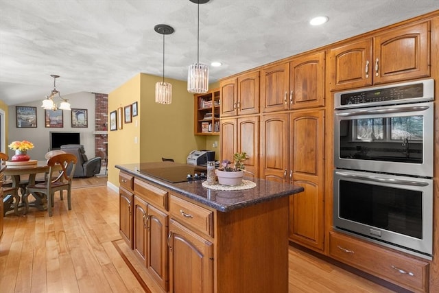 kitchen featuring brown cabinetry, a kitchen island, light wood finished floors, black electric stovetop, and stainless steel double oven