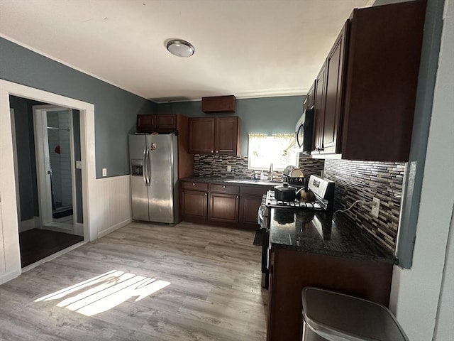 26 Woodman St, Lynn, MA 01905 - kitchen featuring stainless steel appliances, light wood-style flooring, tasteful backsplash, wainscoting, and dark brown cabinets