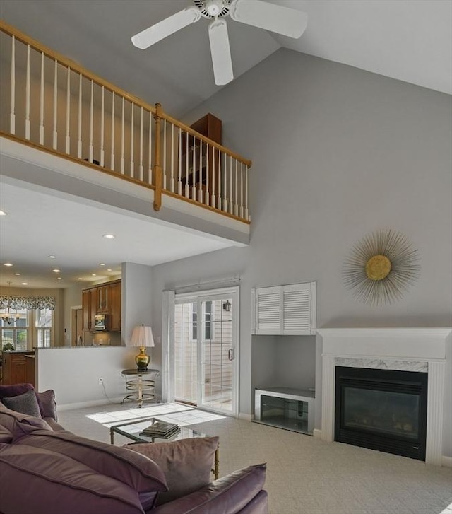 living area featuring carpet, a ceiling fan, and high vaulted ceiling