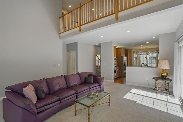living room featuring light colored carpet, recessed lighting, baseboards, and stairs
