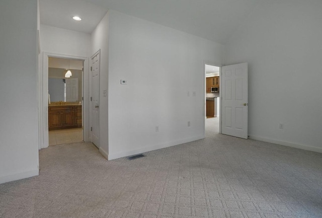 empty room featuring light carpet, baseboards, and visible vents