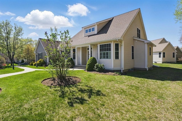view of front facade featuring a front yard and a shingled roof