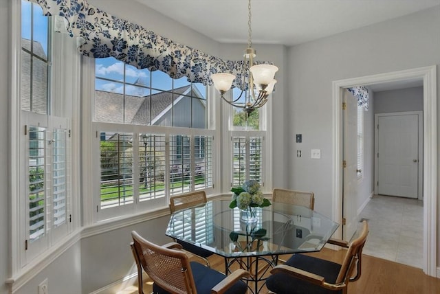dining space with baseboards, a healthy amount of sunlight, and a notable chandelier