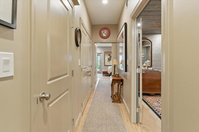 hallway with light wood finished floors and baseboards