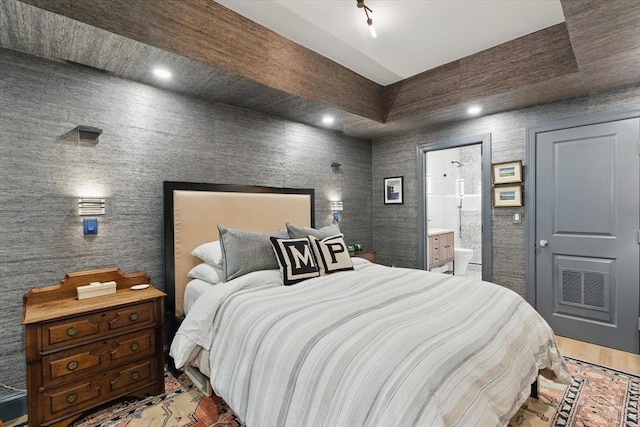 bedroom with ensuite bathroom and recessed lighting