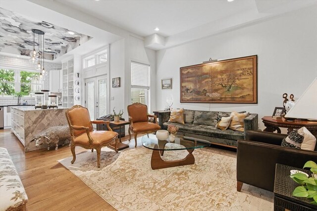 living area featuring a tray ceiling, light wood-type flooring, and recessed lighting