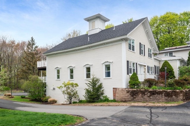 view of side of property with roof with shingles